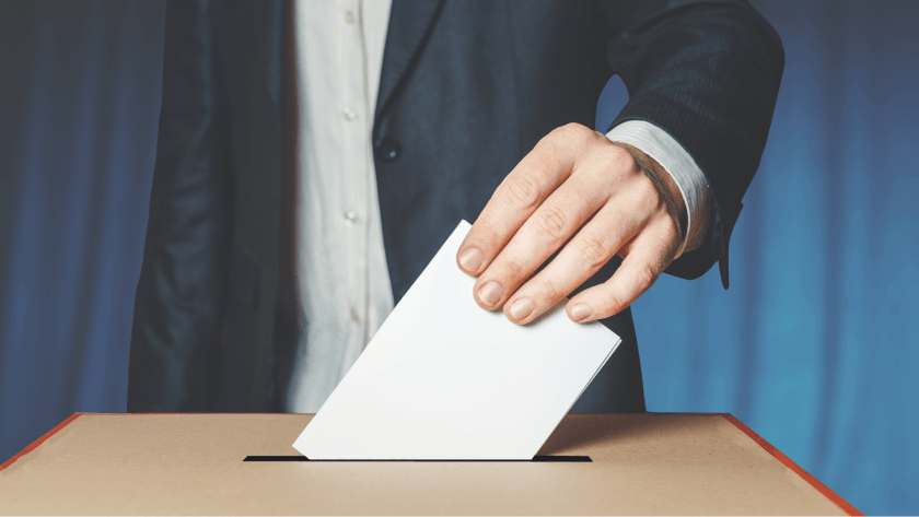Osoba wkłada kartkę do urny wyborczej